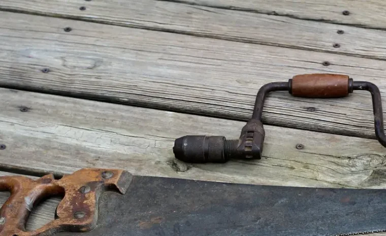 Parts of a saw and a wrench on top of wooden planks