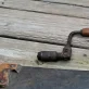 Parts of a saw and a wrench on top of wooden planks